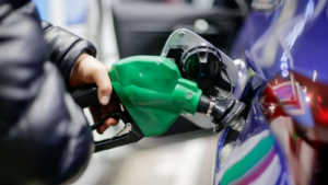 Persona carga combustible en un auto con una pistola de surtidor verde