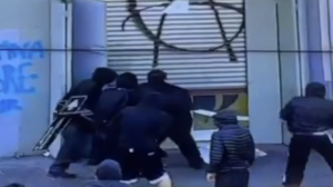 Encapuchados intentan forzar la cortina metálica de un local durante la marcha