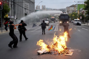 Encapuchados y barricada en llamas frente a un carro lanzaaguas durante el 18-O