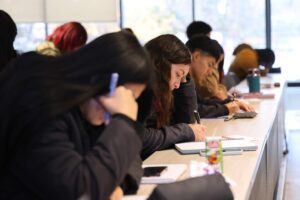 Estudiantes universitarios toman apuntes en una sala de clases
