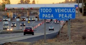 Letrero de Todo vehículo paga peaje junto a una plaza de peaje en la carretera