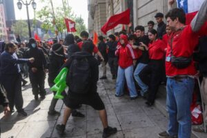 Encapuchados y manifestantes se enfrentan en una calle del centro de Santiago